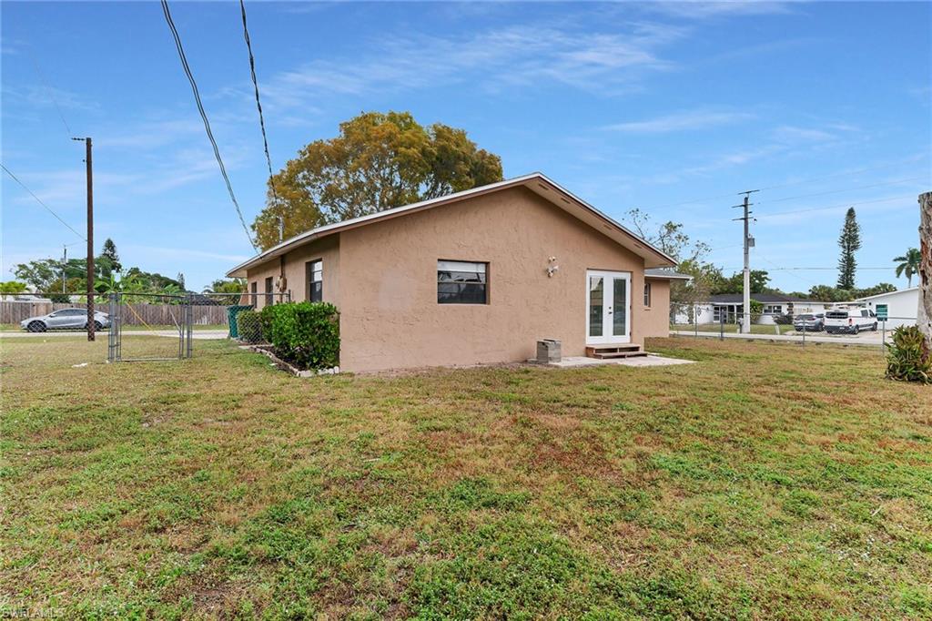Rear view of house featuring french doors, stucco siding, a gate, and a patio