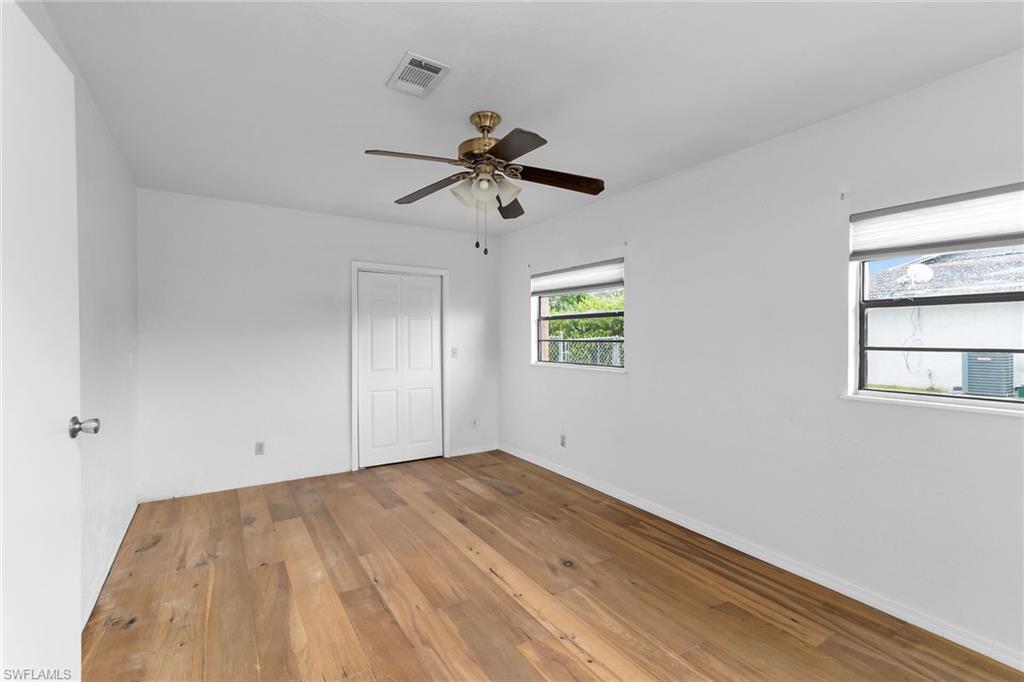 Unfurnished bedroom with light wood-style floors, a ceiling fan, and a closet