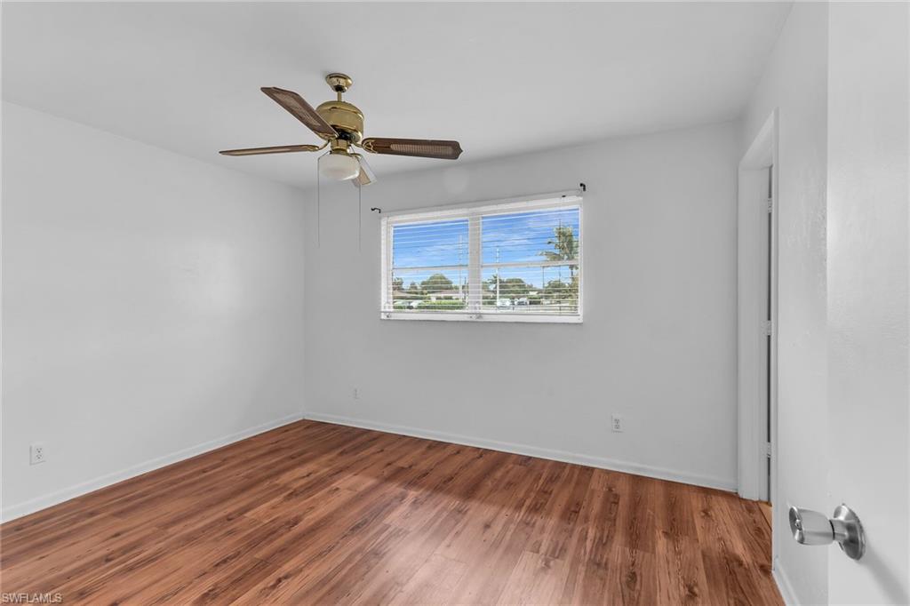 Unfurnished room with wood finished floors and a ceiling fan