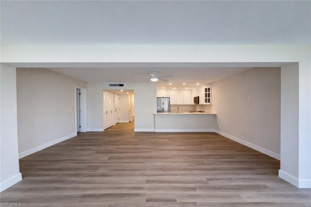 Unfurnished living room featuring light wood-type flooring and ceiling fan
