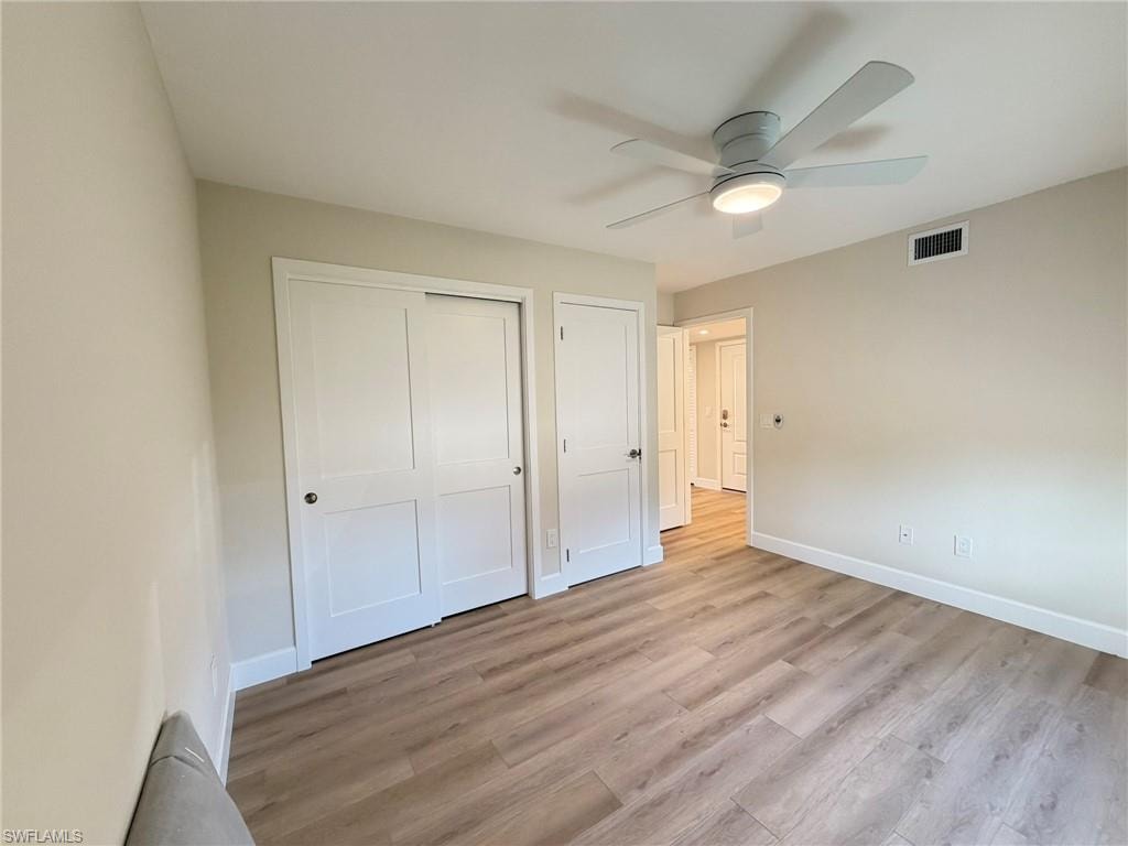 Unfurnished bedroom featuring light wood finished floors, a closet, and a ceiling fan
