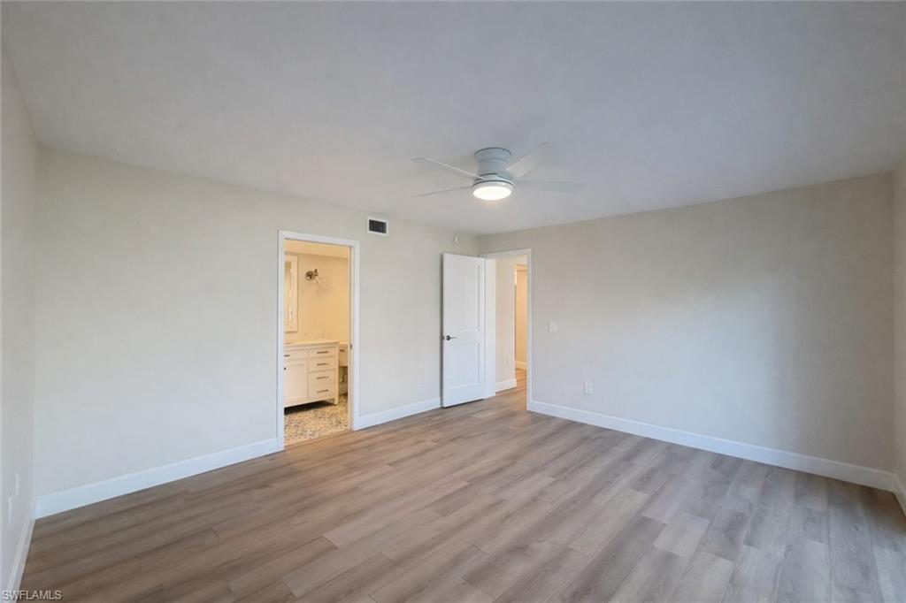Unfurnished bedroom featuring light wood-type flooring, a ceiling fan, and ensuite bath