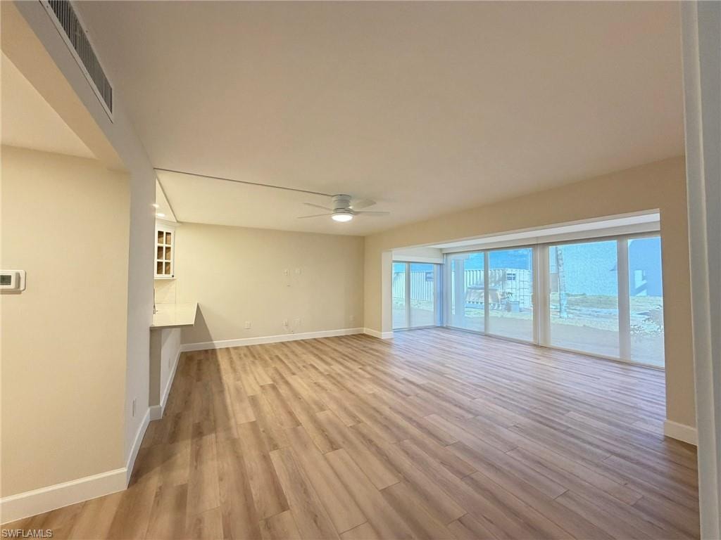 Unfurnished living room with light wood-style flooring and a ceiling fan