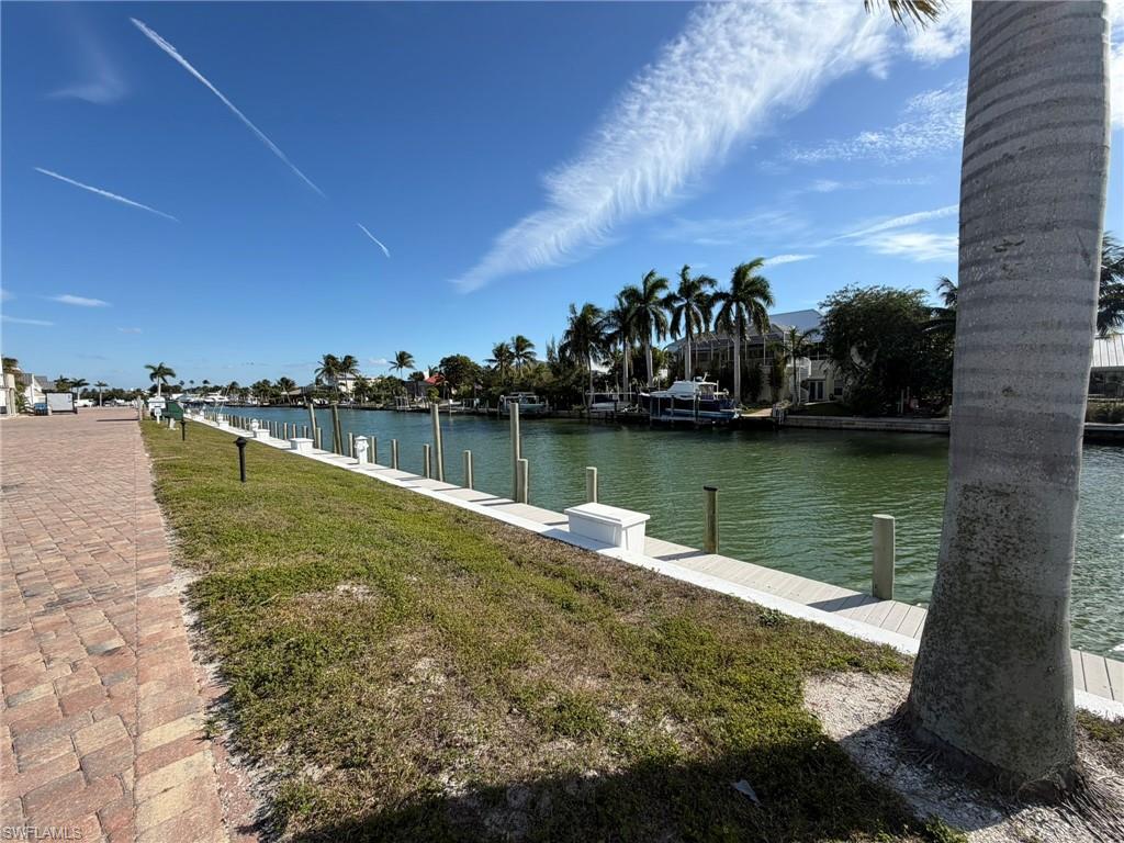 Dock area with a water view and a lawn