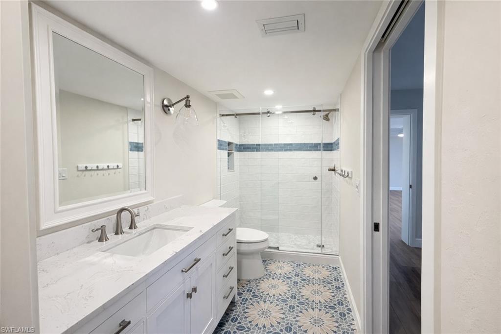 Full bath featuring a shower stall, vanity, and recessed lighting