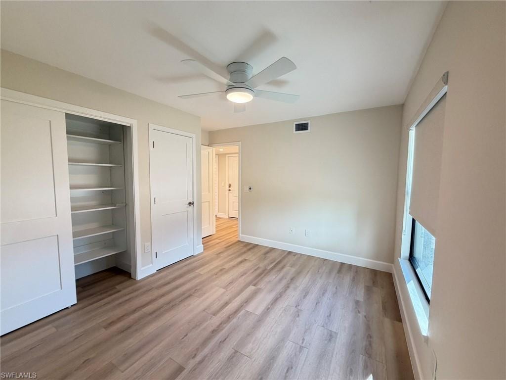 Unfurnished bedroom with a closet, light wood-style floors, and ceiling fan