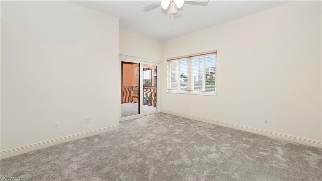Carpeted empty room with baseboards and ceiling fan