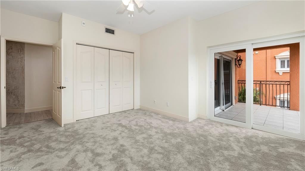 Unfurnished bedroom featuring carpet floors, a closet, access to outside, and ceiling fan