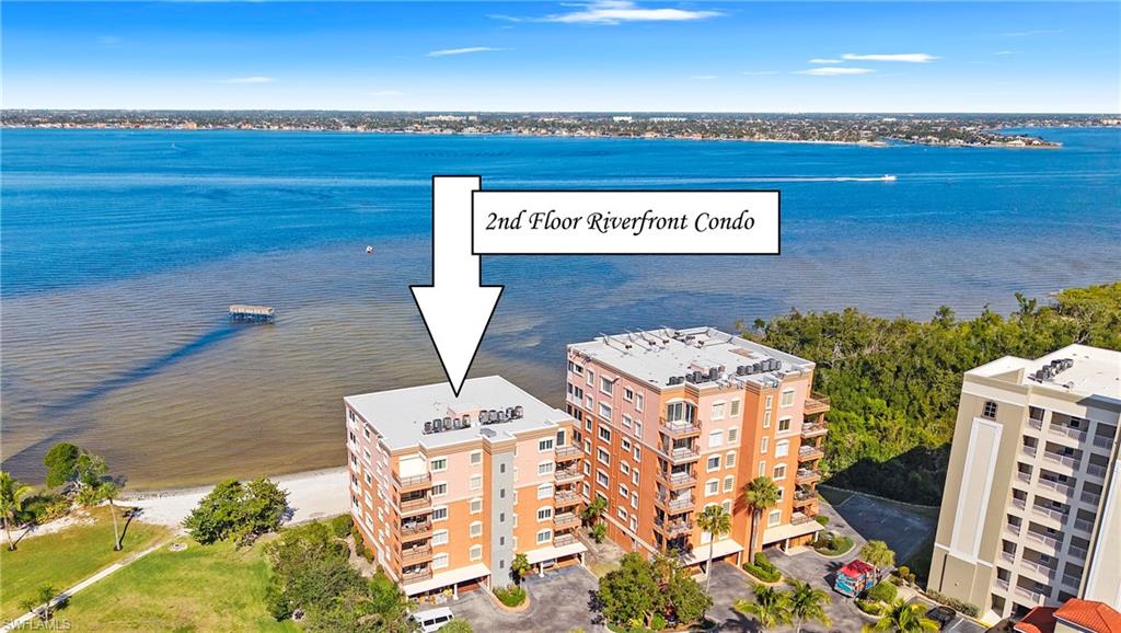 Drone / aerial view of a nearby body of water and apartment complex / building