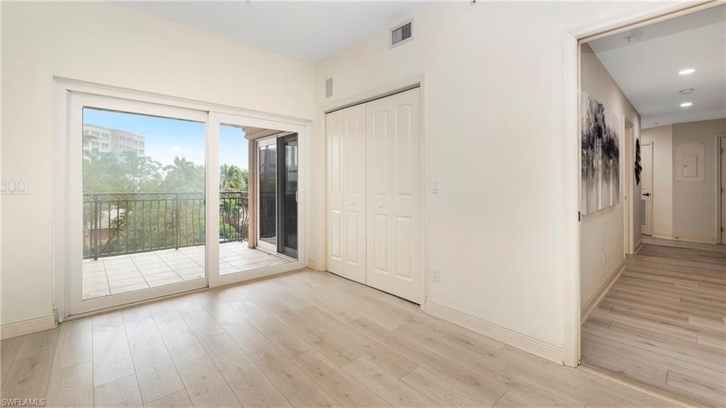 Unfurnished bedroom featuring access to exterior, light wood finished floors, and a closet
