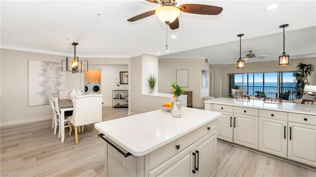 Kitchen with hanging light fixtures, open floor plan, recessed lighting, light wood-style flooring, and a kitchen island