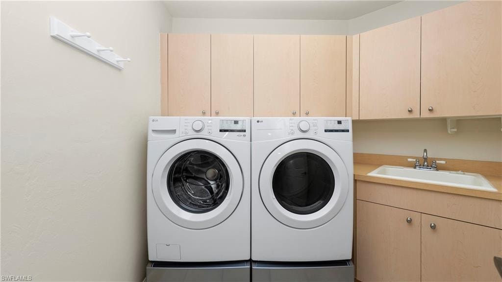 Washroom featuring cabinet space and washing machine and dryer