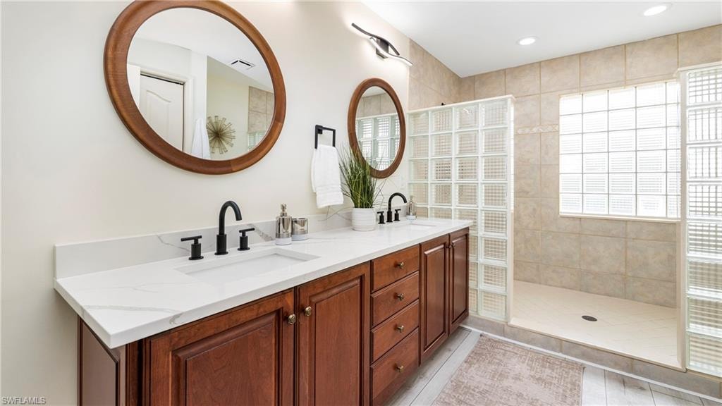 Full bath featuring double vanity, a walk in shower, and recessed lighting