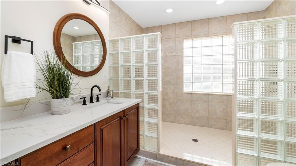 Full bathroom featuring vanity, walk in shower, and recessed lighting