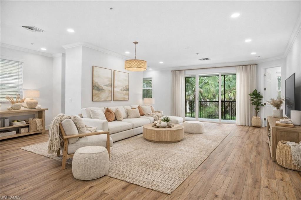 Living room with ornamental molding, light wood-type flooring, and recessed lighting