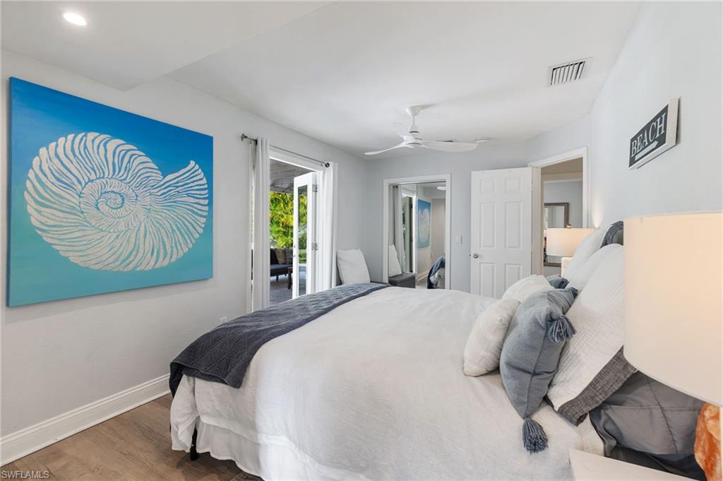 Bedroom with wood finished floors, access to exterior, and ceiling fan