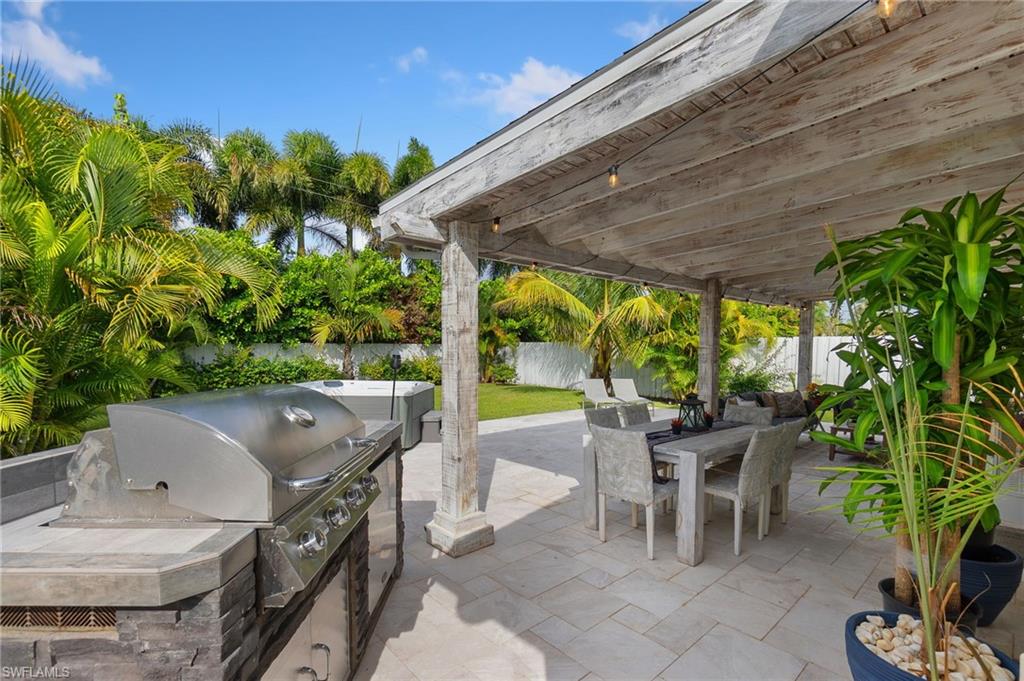 Fenced backyard featuring outdoor dining space, a patio, and exterior kitchen