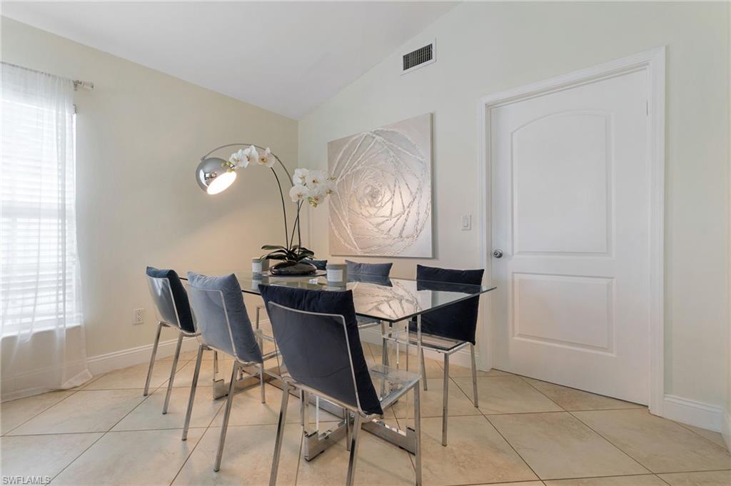 Dining space with vaulted ceiling and light tile patterned floors