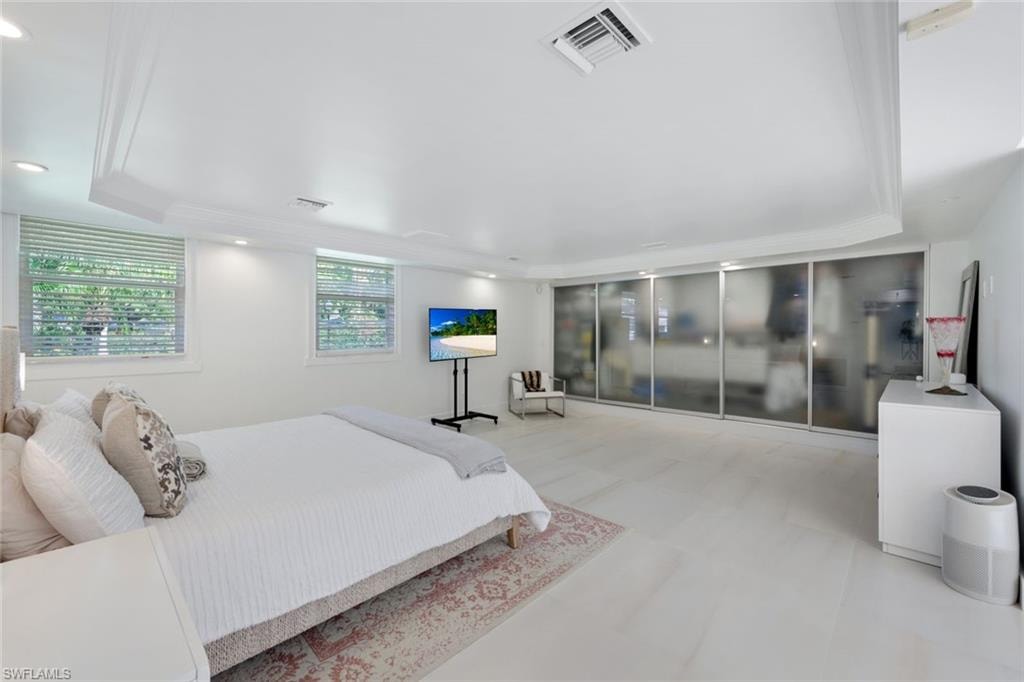 Spacious Primary bedroom with tray ceilings, built in custom closet shelving