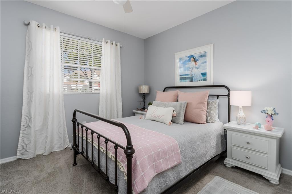 Carpeted bedroom featuring baseboards and a ceiling fan