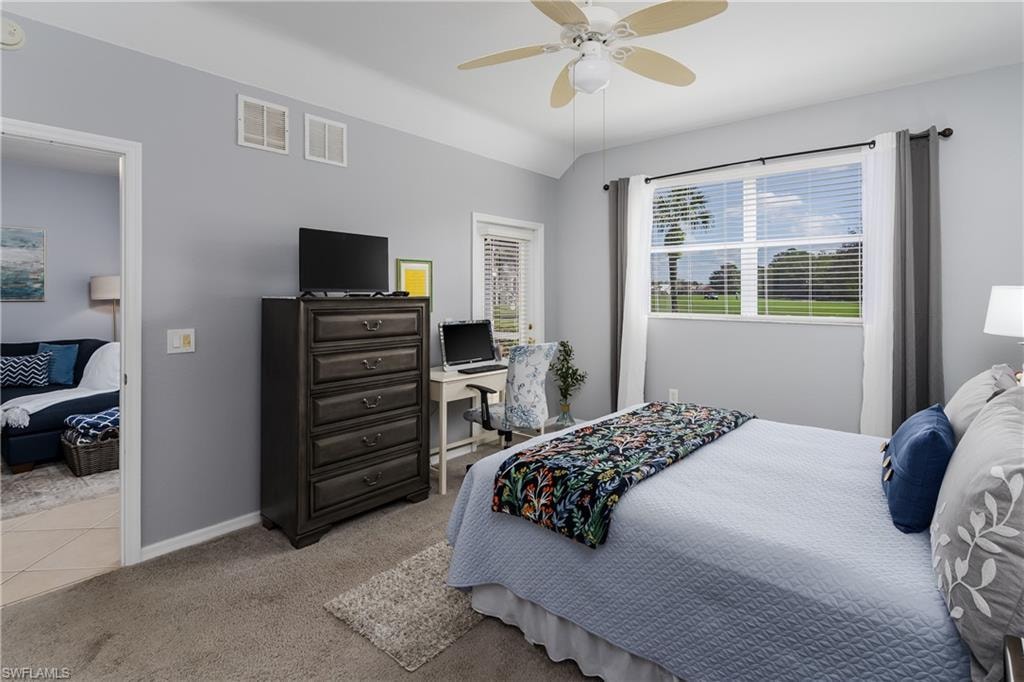 Bedroom with light carpet, ceiling fan, and lofted ceiling