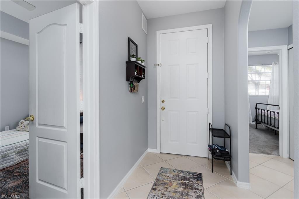 Foyer entrance with arched walkways and light tile patterned floors