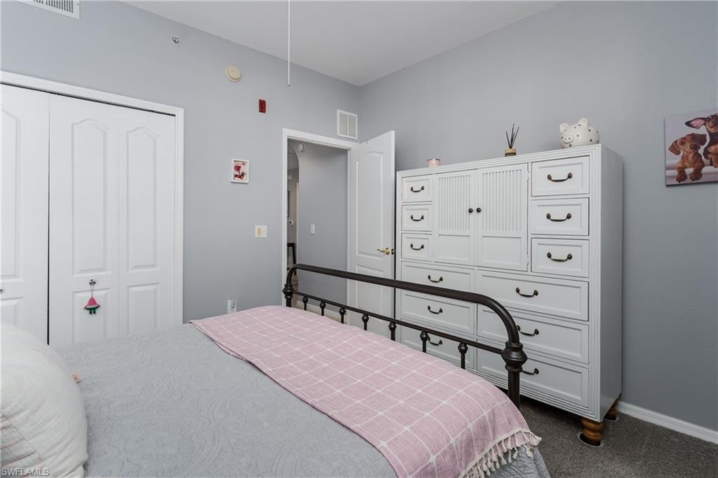 Bedroom featuring dark colored carpet and a closet