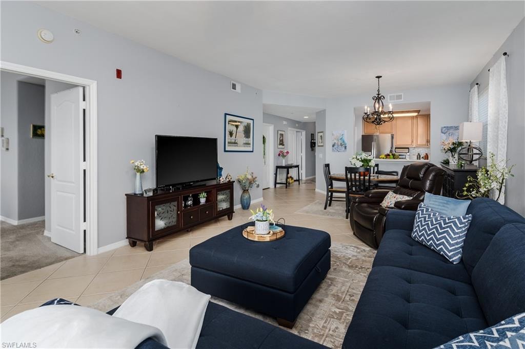 Living area with light tile patterned flooring and a chandelier