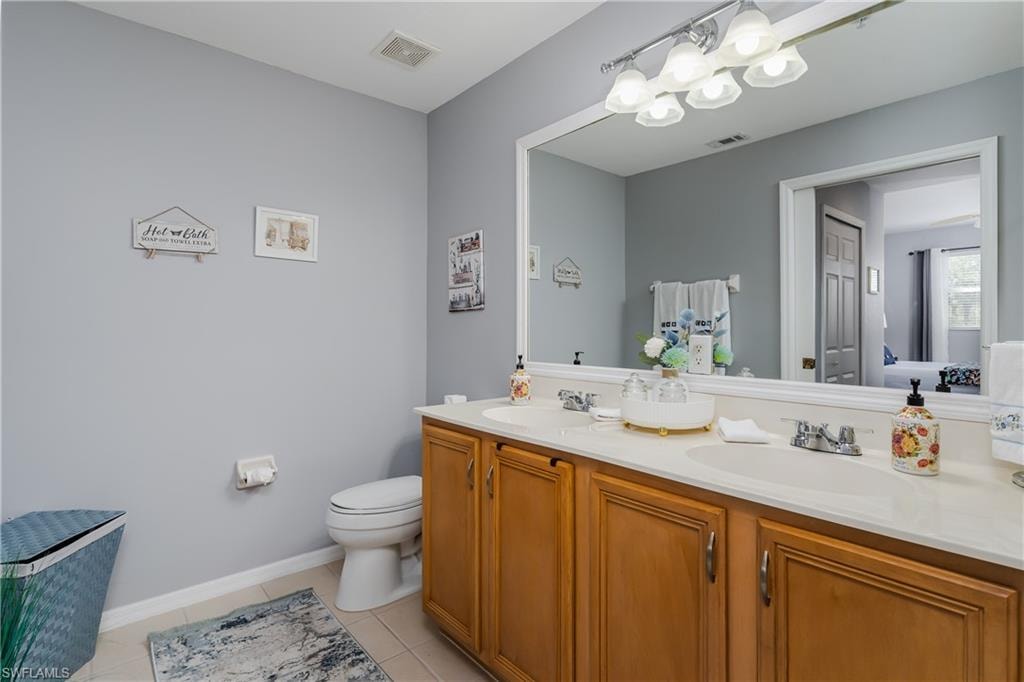 Full bathroom with double vanity and light tile patterned floors