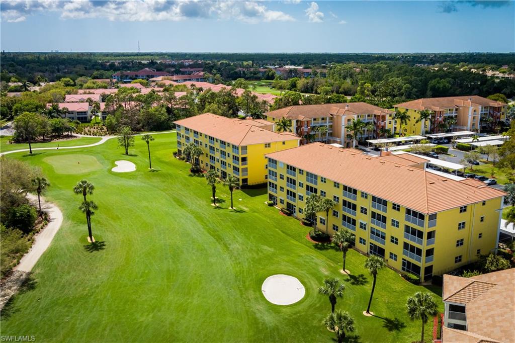 Drone / aerial view of a golf course and apartment complex / building