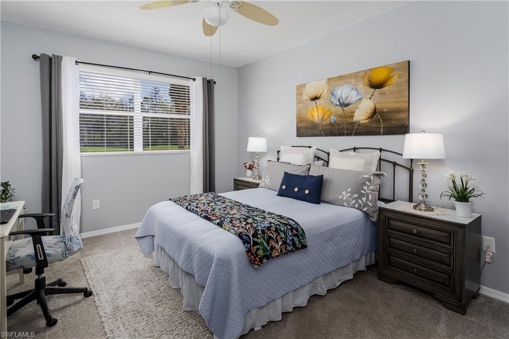 Bedroom with carpet, a ceiling fan, and a desk