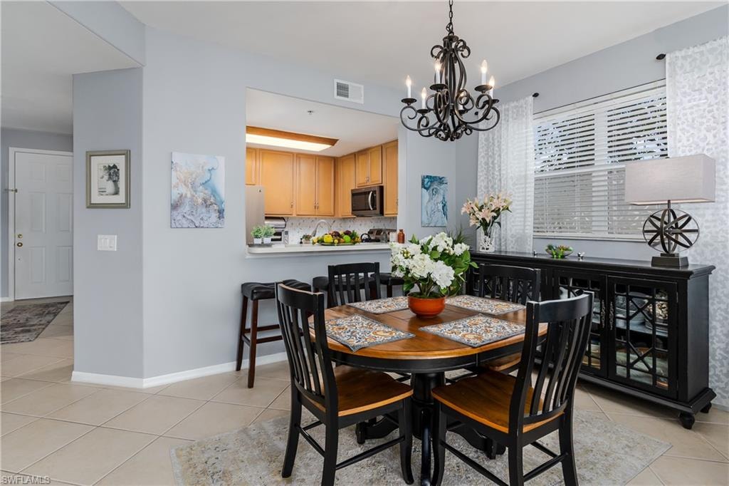 Dining area with light tile patterned flooring and a chandelier