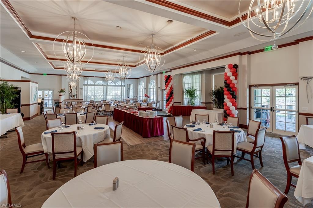 Dining area with hanging lights, french doors, plenty of natural light, ornamental molding, and a tray ceiling
