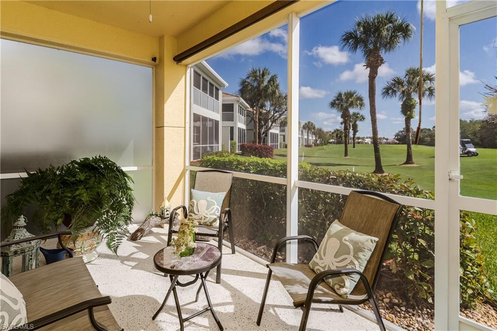 Sunroom featuring view of golf course and healthy amount of natural light