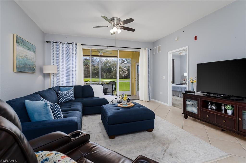 Living room with light tile patterned flooring and ceiling fan