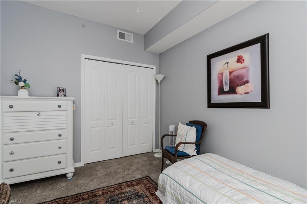 Bedroom featuring dark carpet and a closet