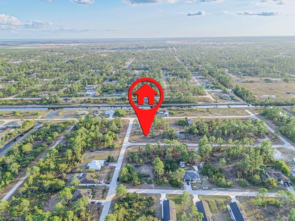 Aerial view of property and surrounding area featuring nearby suburban area