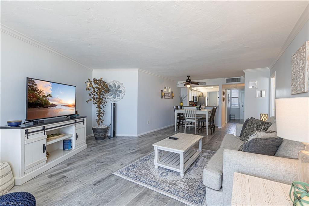 Living room with ornamental molding, hardwood / wood-style floors, and ceiling fan