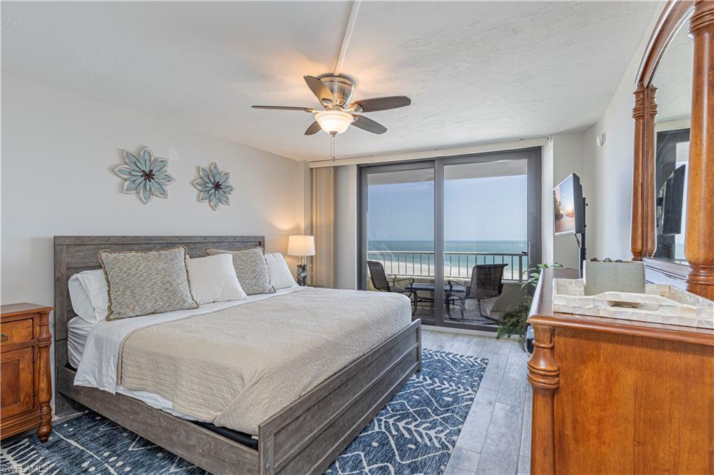 Bedroom featuring floor to ceiling windows, ceiling fan, dark hardwood / wood-style floors, and access to exterior
