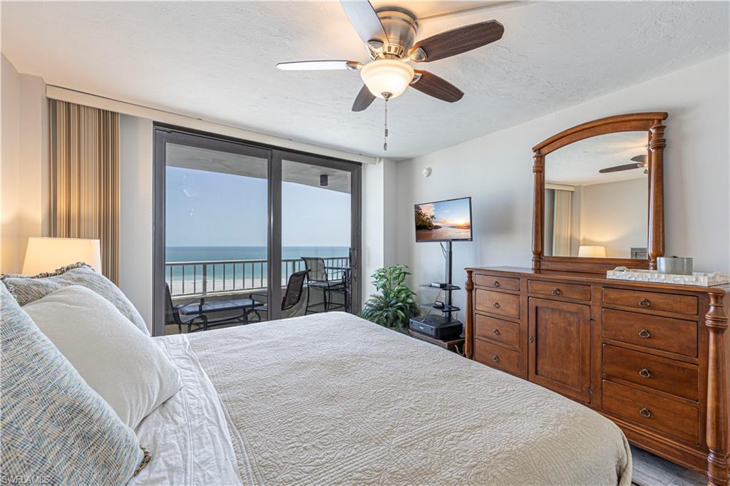 Bedroom with light hardwood / wood-style floors, a textured ceiling, access to outside, ceiling fan, and a wall of windows