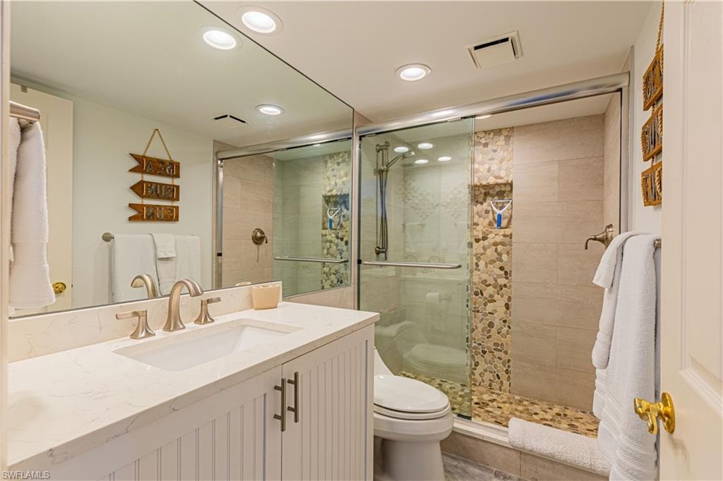 Bathroom with walk in shower, vanity, and toilet