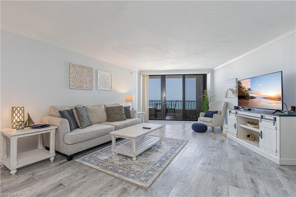 Living room featuring light hardwood / wood-style floors, expansive windows, and crown molding