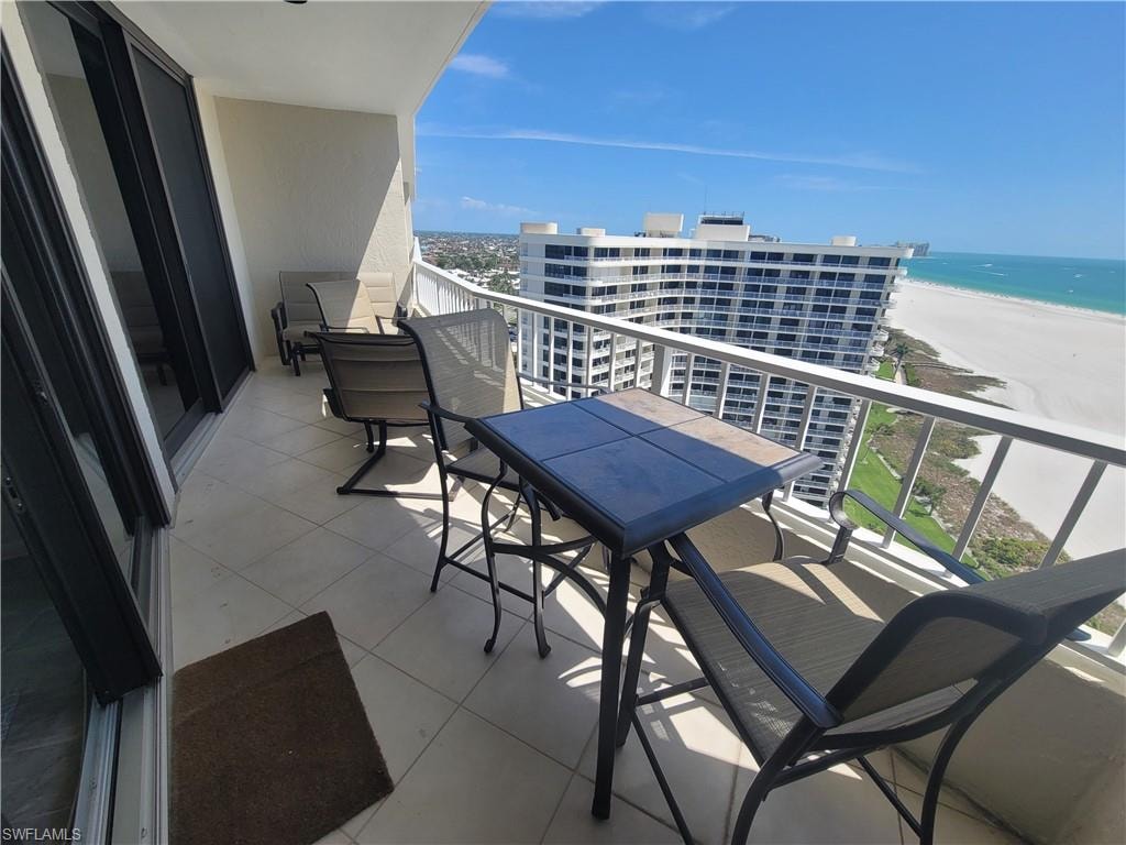 Balcony featuring a water view and a beach view