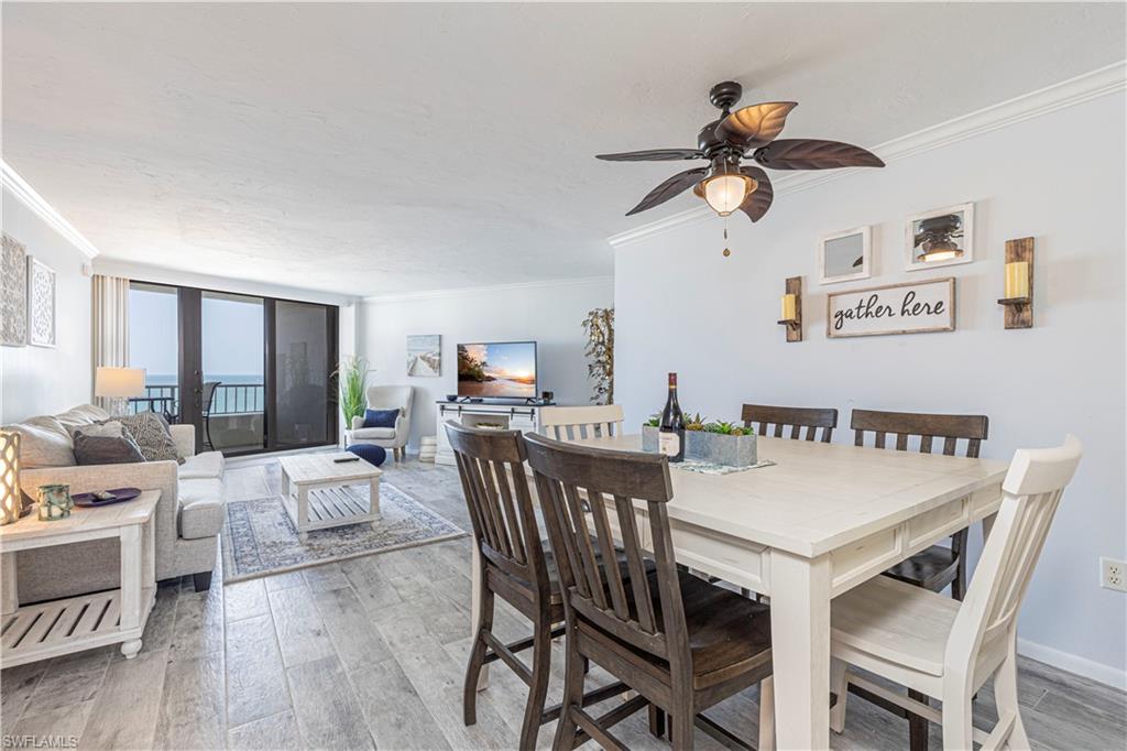 Dining area with wood-type flooring, crown molding, and ceiling fan