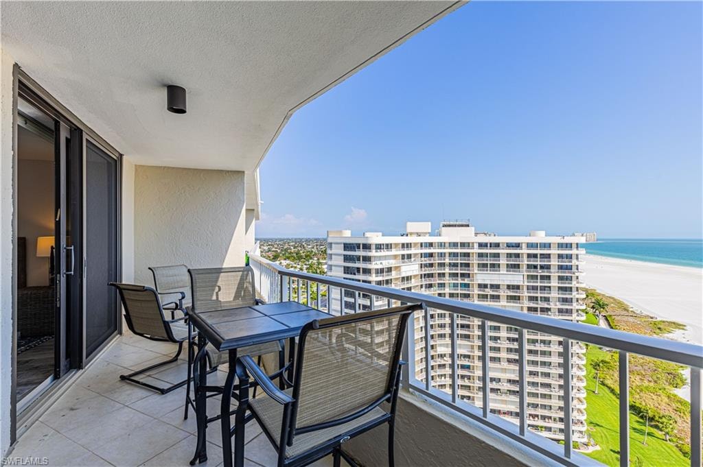 Balcony featuring a water view and a view of the beach