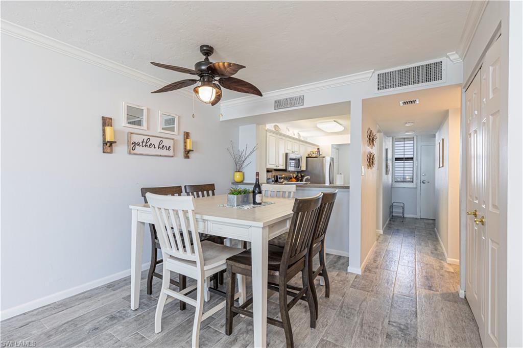 Dining area with ceiling fan, light hardwood / wood-style flooring, and ornamental molding