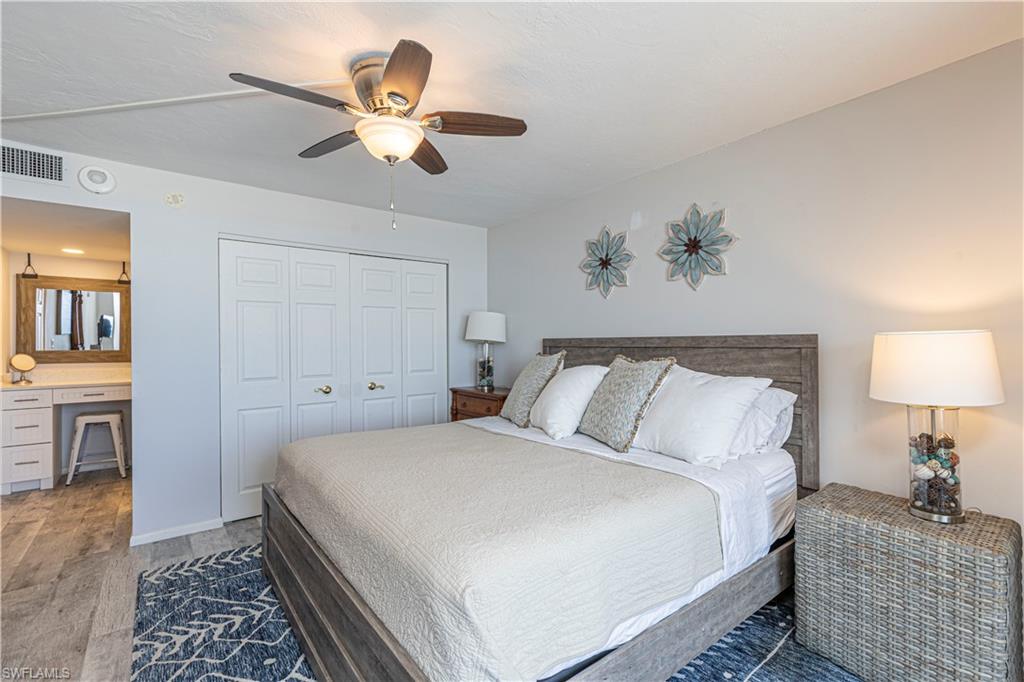 Bedroom with wood-type flooring, ceiling fan, and a closet