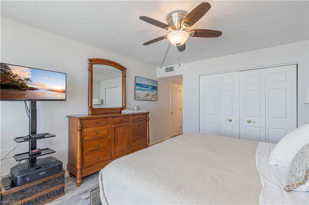 Bedroom with light hardwood / wood-style floors, ceiling fan, and a closet