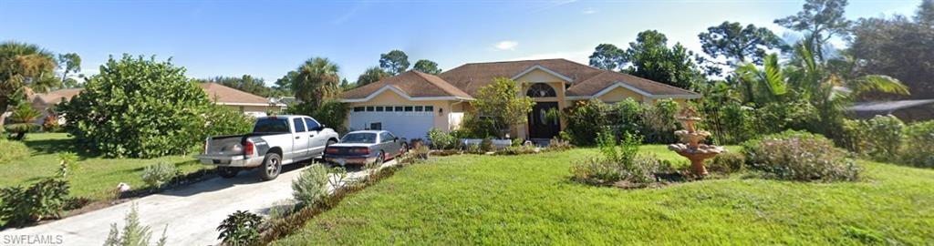 View of front of house featuring a front yard, driveway, and an attached garage