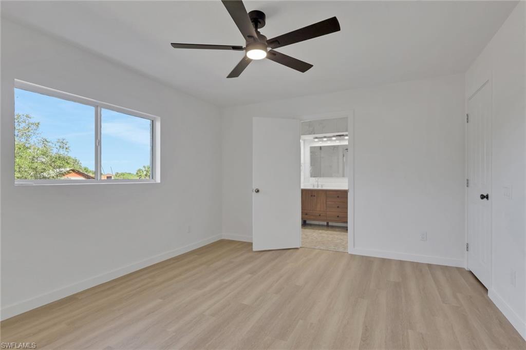 Unfurnished bedroom featuring light wood-style flooring, a ceiling fan, and ensuite bathroom